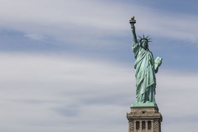 Statue of liberty against cloudy sky