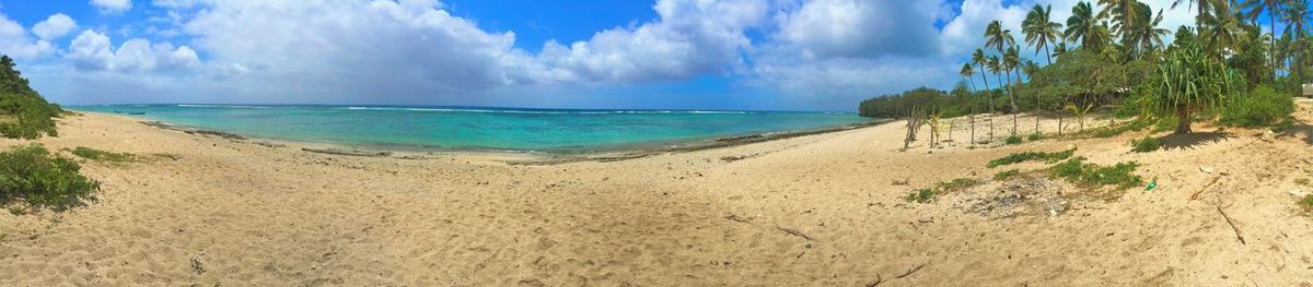 Scenic view of beach against cloudy sky