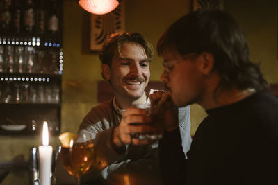 Gay man tasting boyfriend's drink at bar