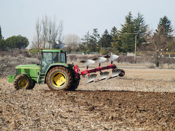 Tractor on field against clear sky