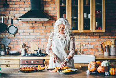 Portrait of young woman preparing food at home