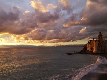 Scenic view of sea against cloudy sky during sunset