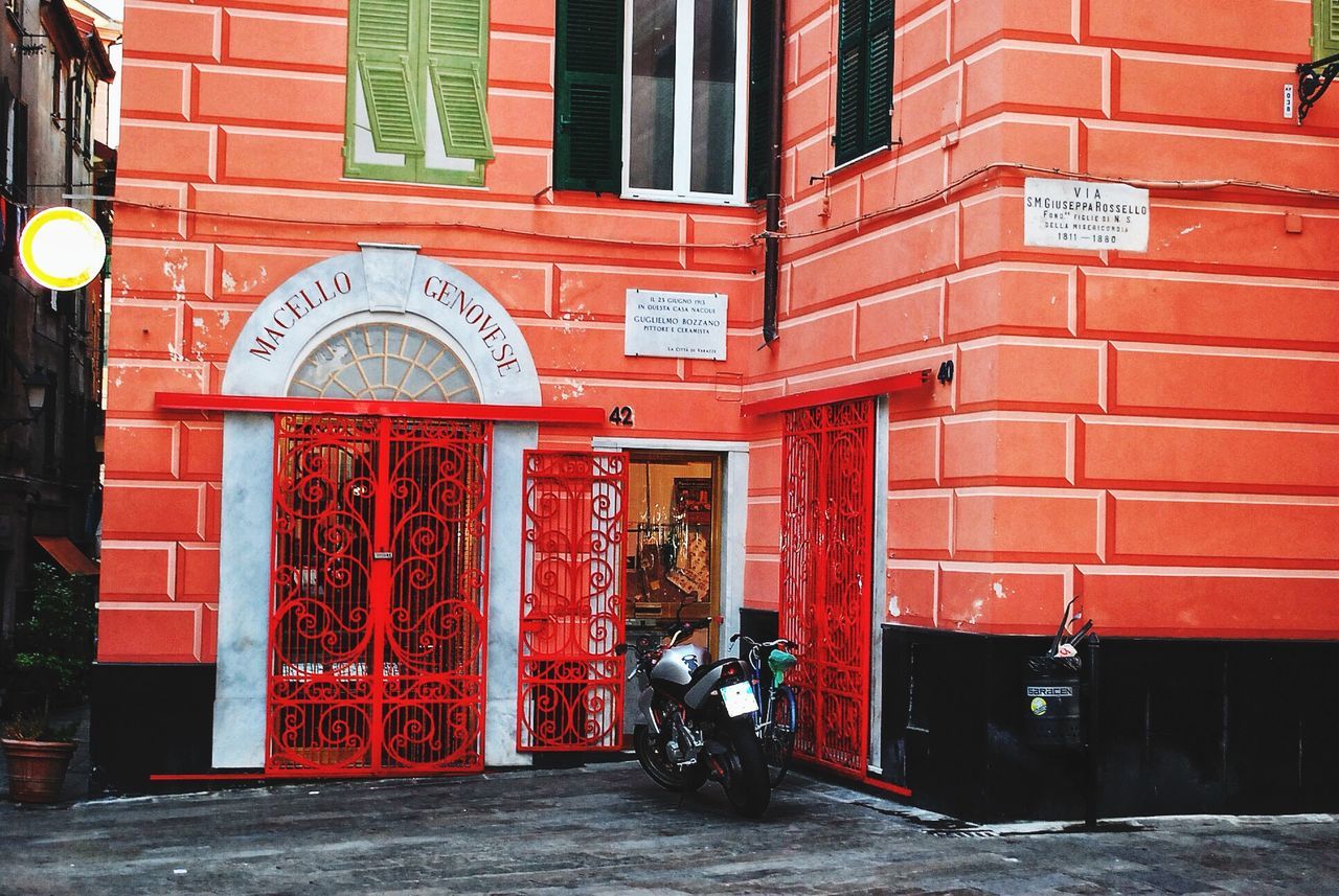 red, architecture, building exterior, built structure, door, entrance, brick wall, closed, text, wall - building feature, city, communication, day, outdoors, building, graffiti, western script, gate, street, no people