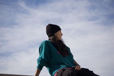 Side view of woman standing against sky