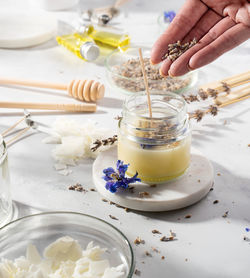 Cropped hand of person preparing food on table