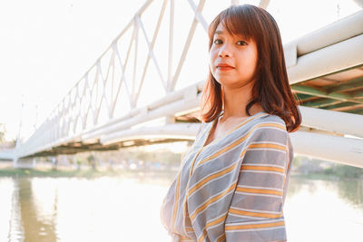 Portrait of beautiful young woman on bridge