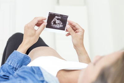 Close-up of pregnant woman lying on bed