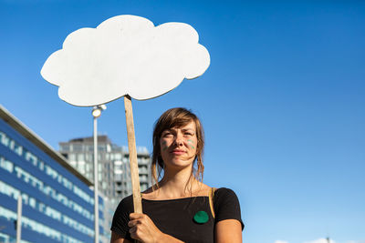 Portrait of beautiful young woman against blue sky