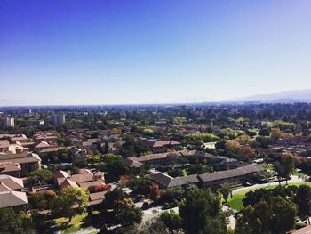 Aerial view of cityscape against blue sky