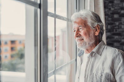Young man looking through window