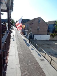 Sidewalk amidst buildings in city against sky