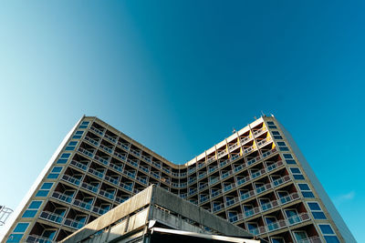 Low angle view of modern building against clear blue sky