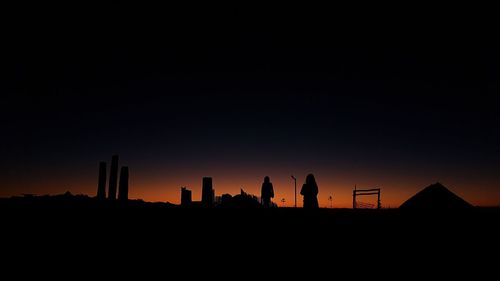 Silhouette buildings against clear sky during sunset
