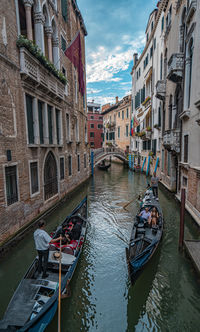 Boats in canal amidst buildings in city