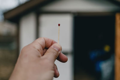 Male hand holding single match.