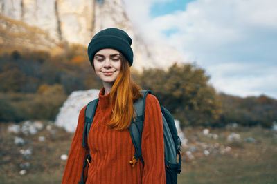 Portrait of smiling young woman standing in park during winter