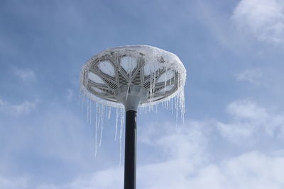 Snow fell on the street lamp. the melting snow formed icicles.