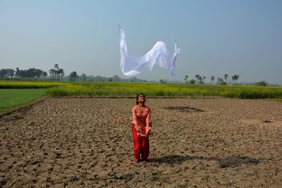 Woman standing on field against sky