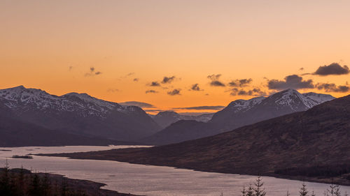 Scenic view of snowcapped mountains against sky during sunset