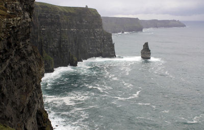 Rock formation by sea against sky