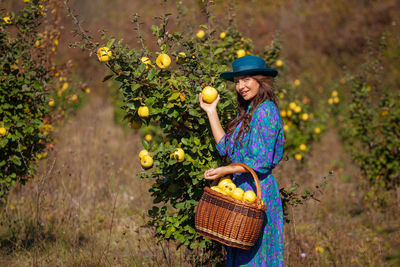 Portrait of woman holding basket in farm