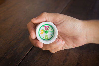 Close-up of human hand holding toy clock