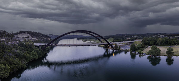 Arch bridge over river against sky