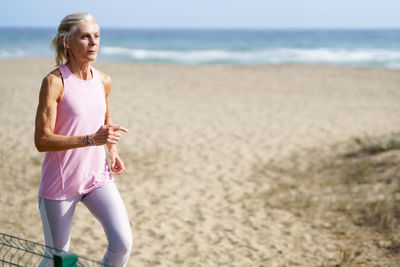 Senior woman running at beach