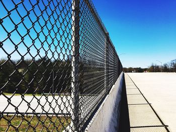 Chainlink fence against clear blue sky