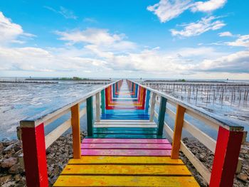 View of empty bridge over sea against sky