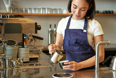 Young woman using mobile phone at cafe