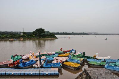 Boats moored in lake against clear sky