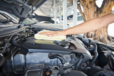 Hand cleaning car engine with a rag,worker
