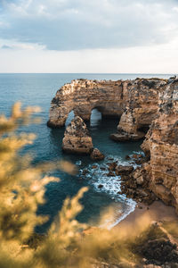 Rock formation in sea against sky