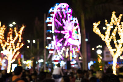 Illuminated ferris wheel in city at night