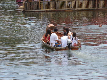 Rear view of people enjoying in canal