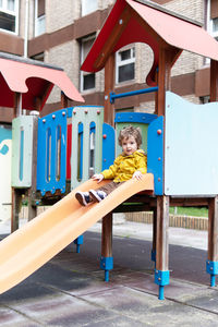 Portrait of boy on playground against building