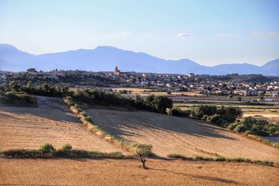 Scenic view of field by mountains against sky
