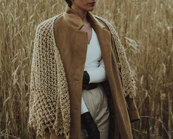 Midsection of woman standing on field