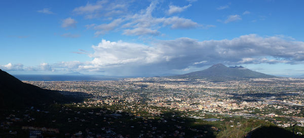 Aerial view of townscape and mountains against sky