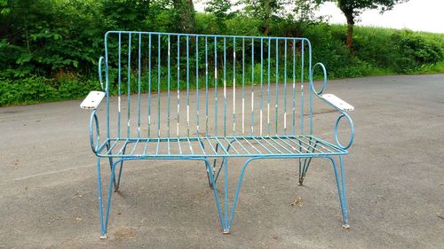 Empty chairs on street in park