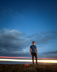 Full length of man standing against blue sky