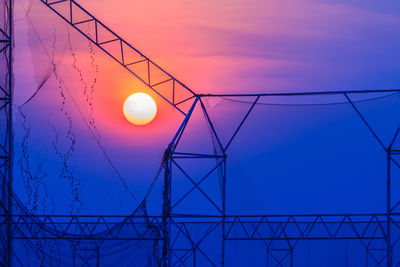 Low angle view of illuminated lamp against sky at sunset