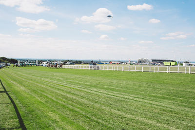 People on grassy field against sky