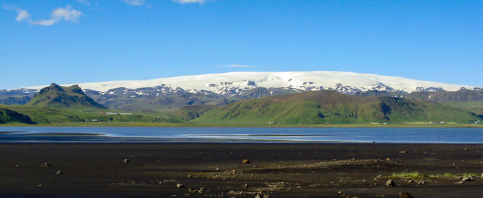 Scenic view of snowcapped mountains against blue sky