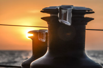 Close-up of coffee cup on table against sunset sky