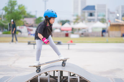 Child or kid girl playing surfskate  in skating rink 