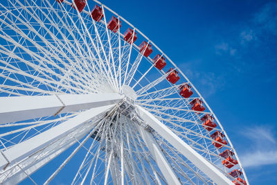 Low angle view of ferris wheel against blue sky