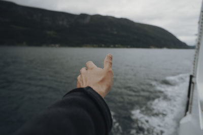 Low section of person on lake against mountain