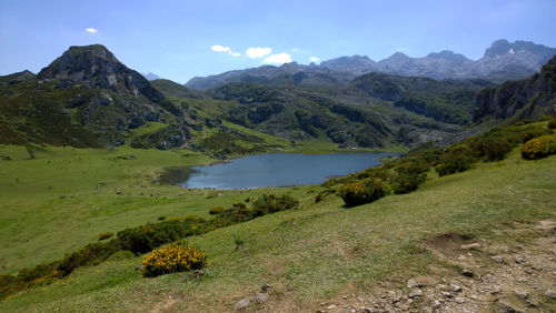 Scenic view of lake and mountains against blue sky